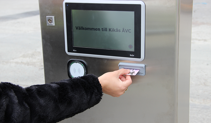 Ett körkort förs in en kortterminal och på skärmen står välkommen till Kikås återvinningscentral 