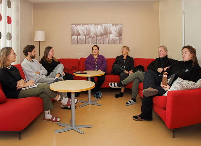arbetslag som sitter i en stor röd soffa
