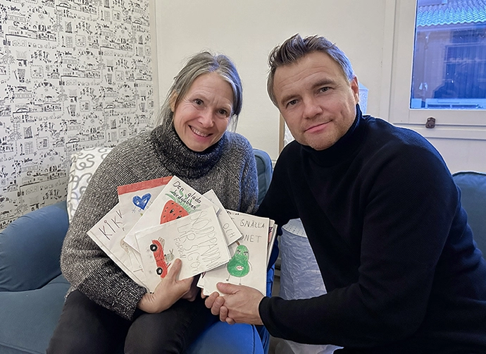 två pedagoger sitter och håller upp böcker