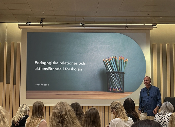 föreläsare står framför presentation inför åhörare