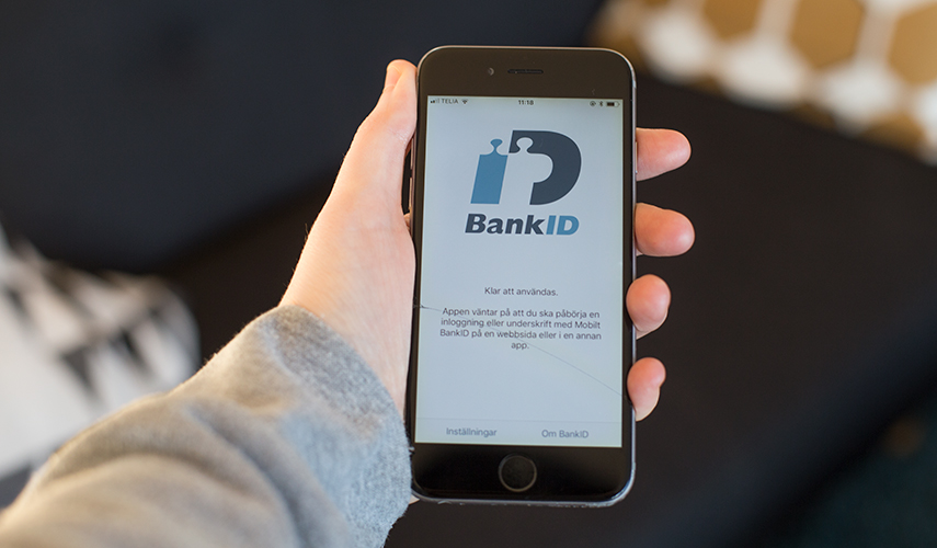 Bild på en hand som håller i en iPhone med appen BankID öppen.