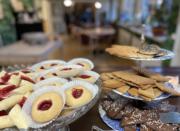 Torrekullagårdens kafé. I förgrunden syns olika småkakor, bland annat hallongrottor. I bakgrunden syns delar av av kaféets interiör. 