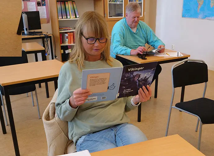 Elever på Lärvux läser ur en bok.