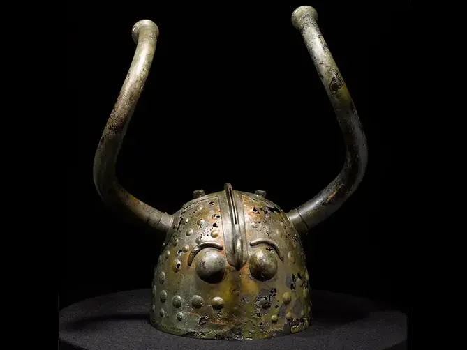 En hjälm i brons med långa vridna horn.