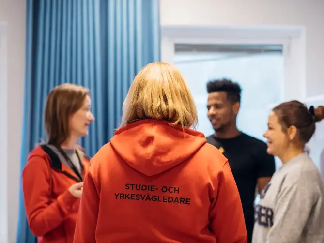 Två studie- och yrkesvägledare pratar med två elever