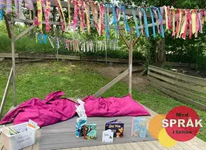 böcker står uppställda på en filt på förskolegårdens gräsmatta