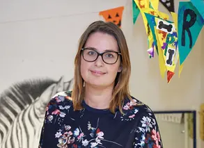 lärare på förskolan  står i närbild och tittar in i kameran